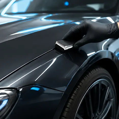 Ceramic coating being applied to paint protection film on a luxury vehicle in San Diego